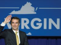 Governor-elect of Virginia Ralph Northam strides onto stage at a campaign event.