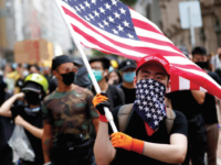 Protesters in Hong Kong carry American flags, seeking the U.S.'s help in securing their rights from China. Photo courtesy of National Review